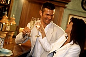 Couple at a bar chinking champagne glasses