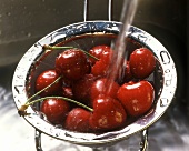 Cherries being washed in strainer