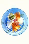 Gemüsecarpaccio mit Sauerampfedip auf blauem Glasteller