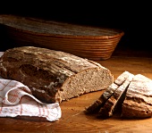 A loaf of rye bread, slice cut, on wooden background