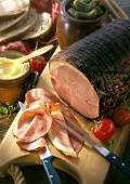 Juniper ham, cut into on wooden board