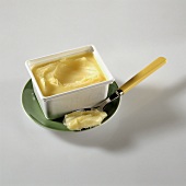 Butterschmalz im Plastikbehälter und auf Löffel