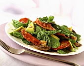 Spinach salad with avocado, salami and mushrooms