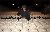 Roquefort-Herstellung: Mann bohrt Löcher für Edelpilz in Käse