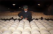 Making Roquefort; man boring holes for mould in cheese