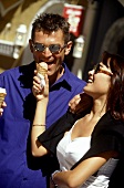 Young woman letting man taste her ice cream