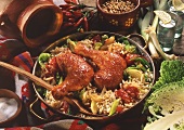 Two chicken legs with savoury rice; decoration: ingredients