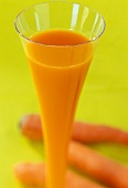 A glass of carrot juice, carrots as decoration