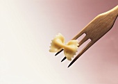 A pasta bow (farfalle) on wooden fork