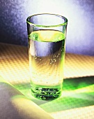 Ein Glas Mineralwasser in grünem Licht