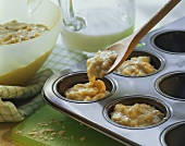 Making banana muffins (spooning the dough into muffin tins)