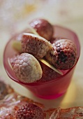 Filled raspberries chocolates in pink glass
