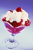 Vanilla ice cream with hot raspberries & cream in glass