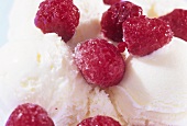 Scoops of vanilla ice cream with fresh raspberries (close-up)