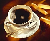 A cup of coffee and wafer roll