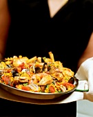 Person holding platter of mixed paella