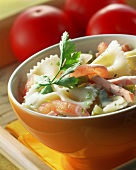 Pasta salad with tomatoes and strips of ham in bowl