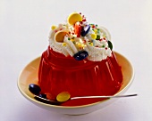 Red jelly with whipped cream & coloured chocolate buttons