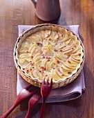 Potato and apple gratin with diced ham in gratin dish
