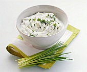 Chive quark in bowl, fresh chives in front