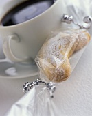 Wrapped almond crescents and a cup of coffee