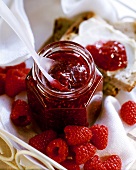 Raspberry jam in a jar and on bread