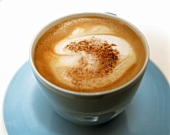 Eine Tasse Cappuccino mit Kakaopulver bestäubt