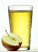 Ein Glas Apfelsaftschorle, davor ein halber Apfel