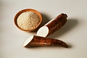 Halved manioc root, bowl of manioc flour beside it