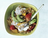 Muesli with fruit and yoghurt in green bowl