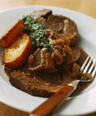 Braised steak with onions with green sauce and toasted bread