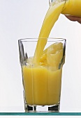 Pouring orange juice into a glass