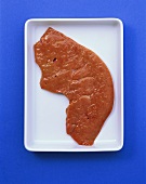 A slice of calf's liver on white bowl