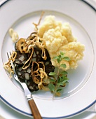 Fried black pudding with onions and mashed potato with apple