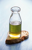 Olive oil in small bottle and a slice of bread