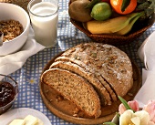 A pumpkin seed loaf with milk, jam, fruit and muesli