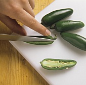 Cutting open green chili peppers