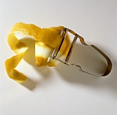 Eine Zitrone mit dem Sparschäler abschälen