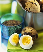Boiled quail's eggs, one halved in foreground