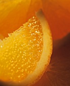Orange slice in front of peeled orange