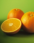 Eine Orangenhälfte und zwei ganze Orangen