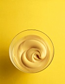 Vanillecreme in einem Glas mit gelbem Hintergrund