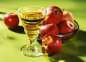 A glass of apple juice and red apples