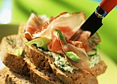 Wholemeal bread with herb butter and ham; with knife