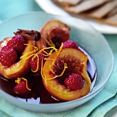 Peaches with raspberries in red wine and cinnamon sauce