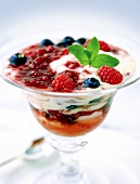 Berry compote with cream in dessert glass