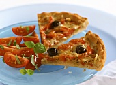 Two pieces of tomato and pepper pizza with olives