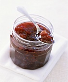 Raspberry and apple jam in jar and on spoon