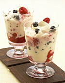 Banana yoghurt with berries in two dessert glasses