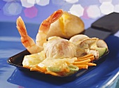 Raclette pan with fried vegetables, shrimps, cheese